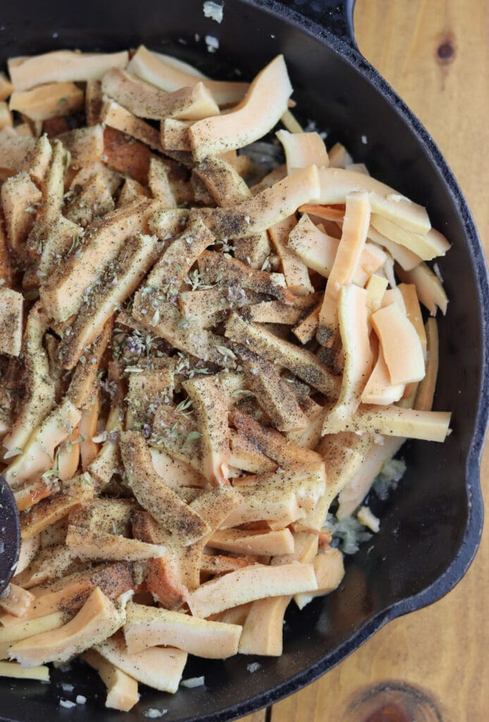 Seasoning sautéed chicken of the woods mushrooms with herbs and spices.